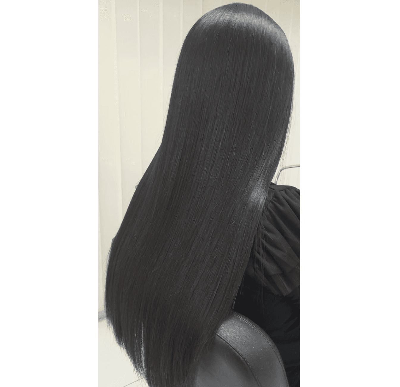 Long, smooth dark hair shown from the back after a keratin treatment.