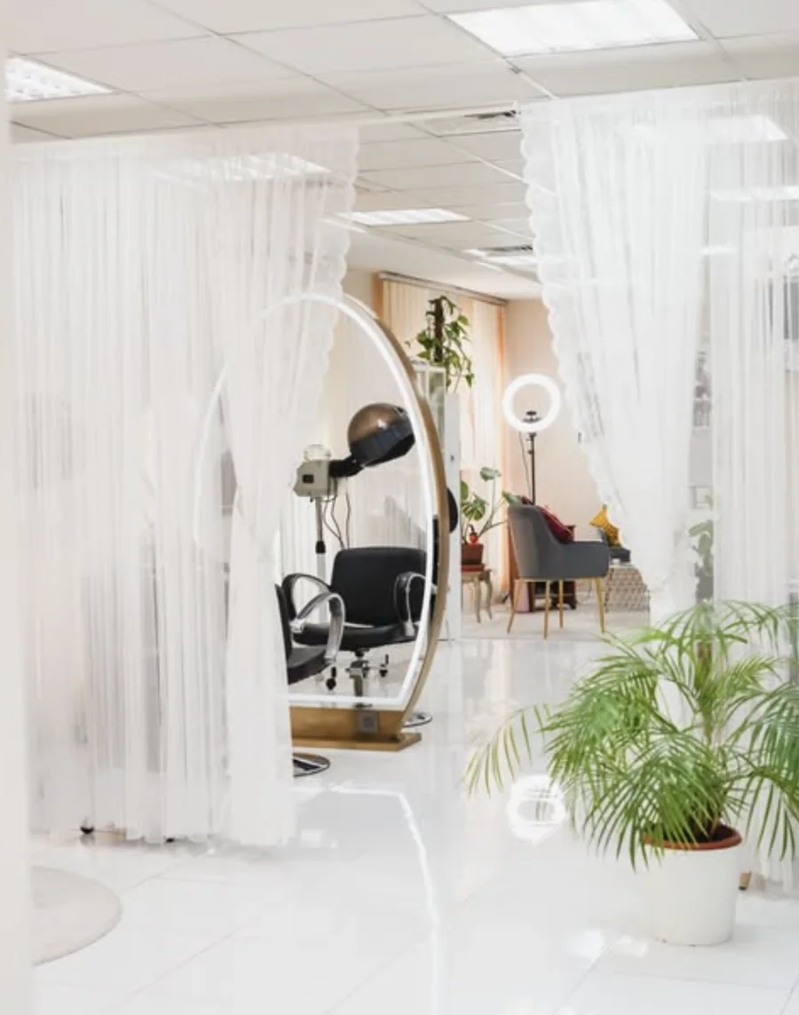 Sheer curtains framing a styling mirror at Vesna Beauty Lounge